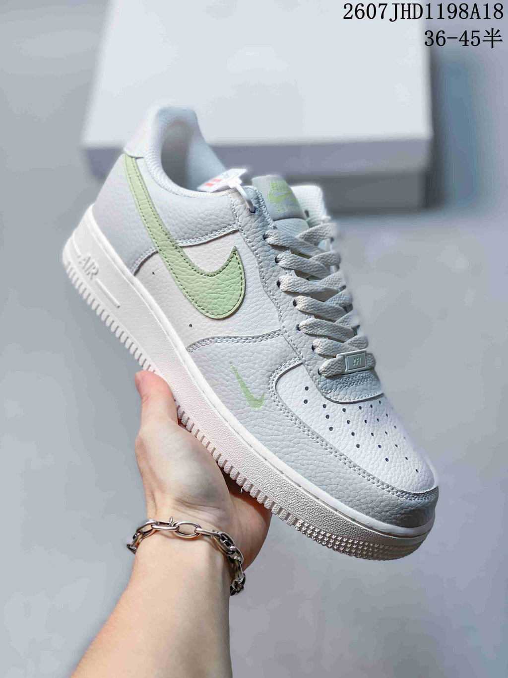 Close-up side view of a white Nike Air Force 1 low-top sneaker with a light green Swoosh and white sole.