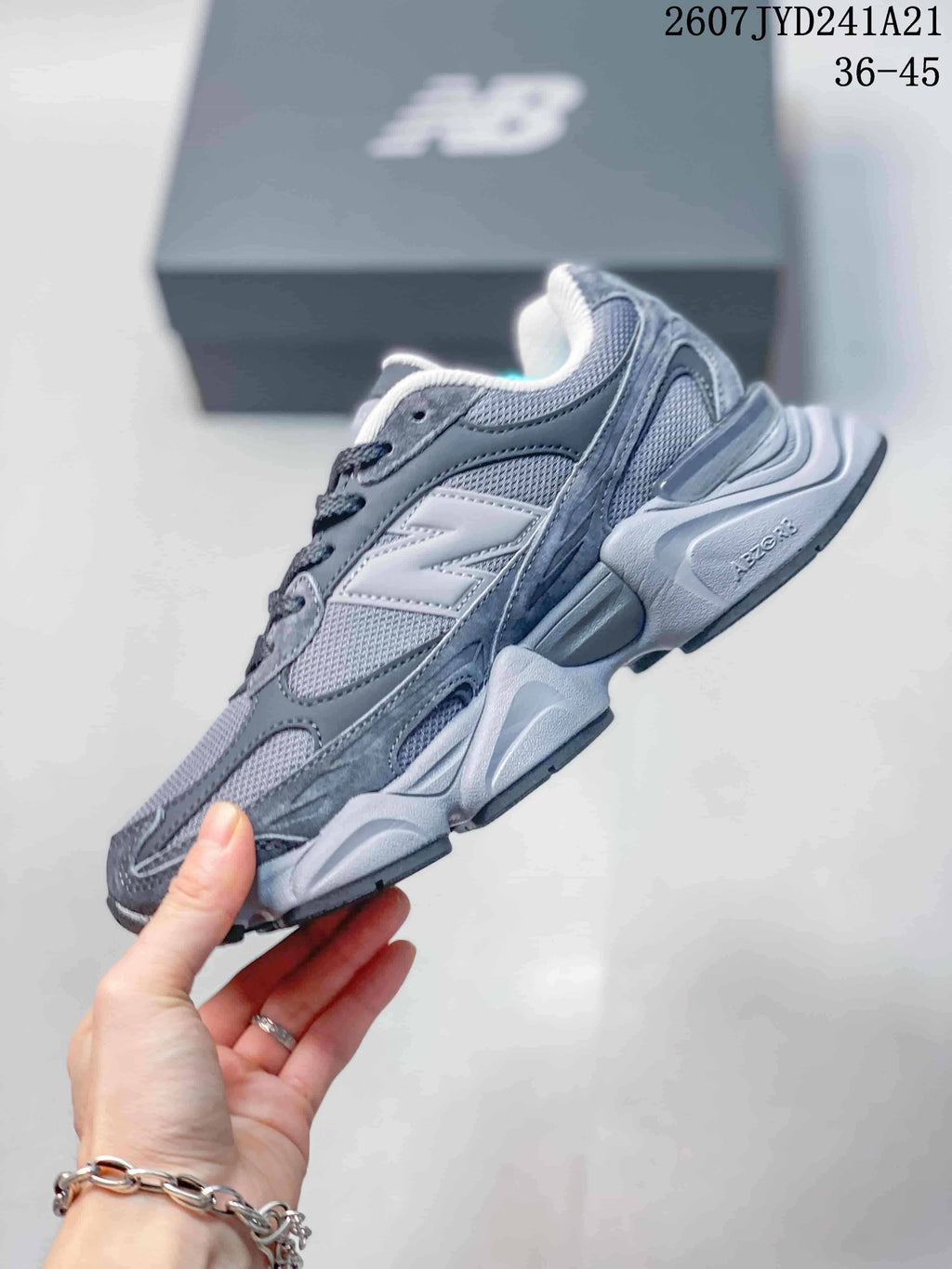 Side profile showing the layered gray upper, large side logo, and sculpted sole.