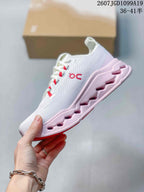 Side view of the white sneaker with red details, a pink sculpted outsole and visible side branding.