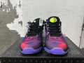 Front view of black and purple Nike basketball-style sneakers with red patterned uppers and black laces