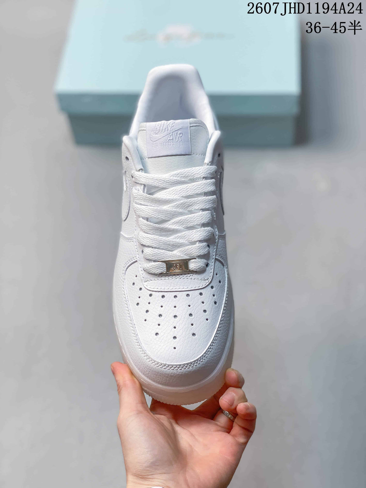 Top view of the white sneaker showing the perforated toe box, laces and metallic lace tag.
