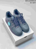 Pair of dark gray Nike Air Force 1 low-top sneakers with graphic lettering, displayed on a shoebox; image text shows style code 2607JLD309A19 and size range 36–46.5.