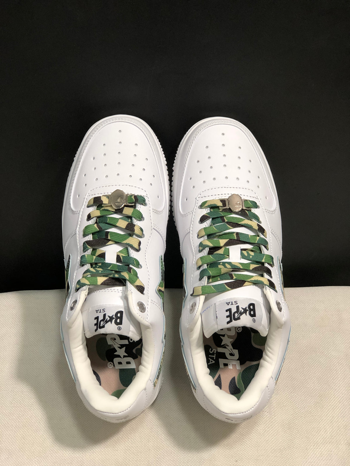 Top view of the pair showing perforated toe boxes, camouflage laces, tongue branding, and camouflage insoles.