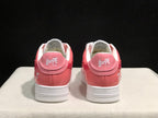 Rear view of the pair showing BAPE Sta heel branding, pink heel panels, and white outsoles.