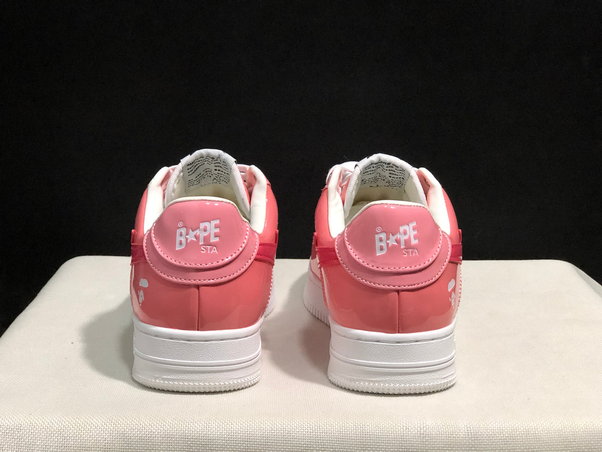 Rear view of the pair showing BAPE Sta heel branding, pink heel panels, and white outsoles.