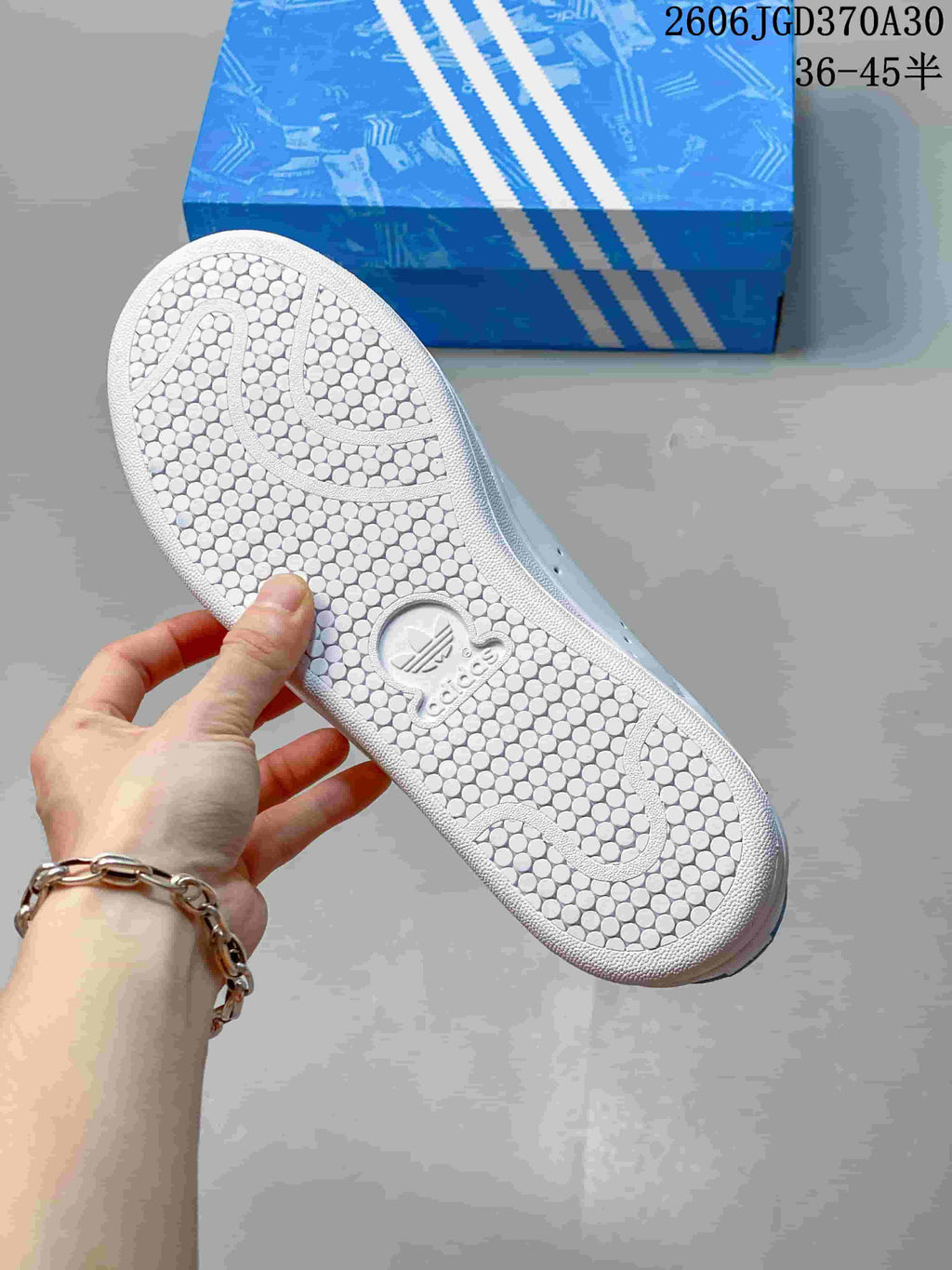 Close-up of the textured outsole on a white Adidas Stan Smith sneaker