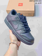 Close side view of a dark gray Nike Dunk Low sneaker with Nike SB tongue branding