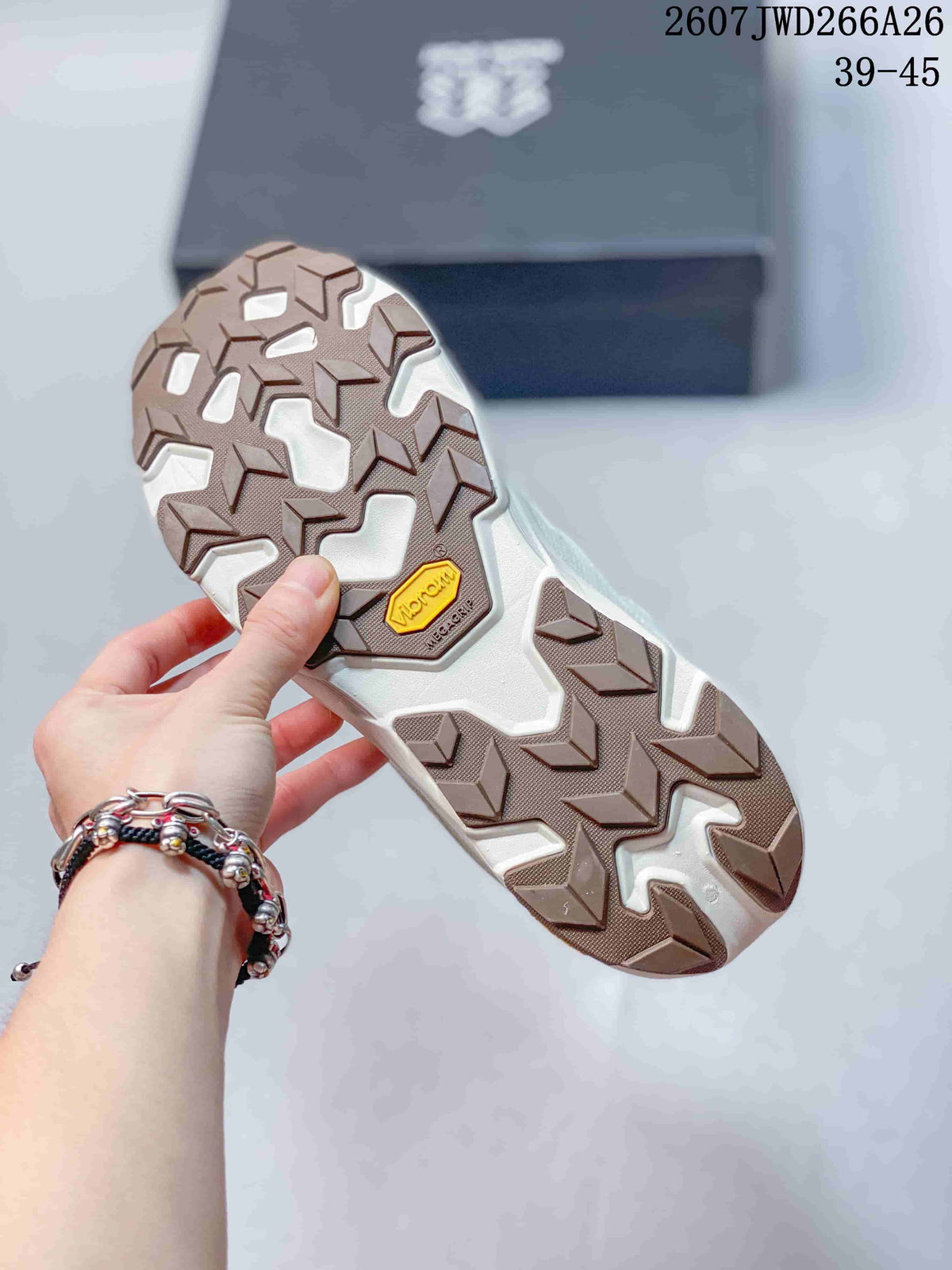 Underside view of the shoe showing a brown-and-white lugged outsole with a visible Vibram mark.