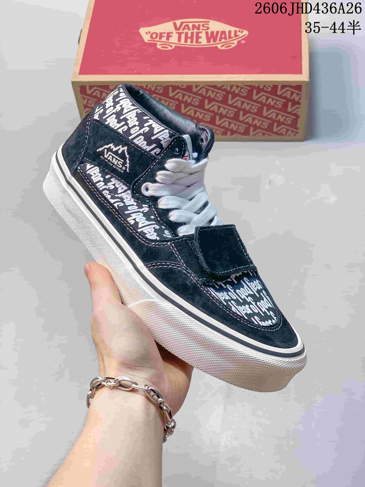 Side view of a black Fear of God x Vans sneaker showing its text-print panels and overlay strap.