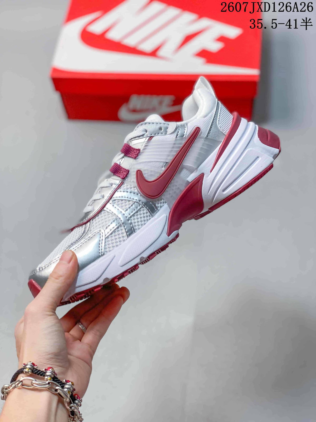 Side view highlighting the layered white and silver upper with red Nike detailing.