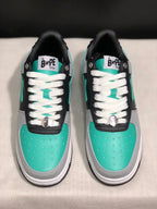 Front top view showing the turquoise toe boxes, white laces, tongue branding and metallic lace hardware.