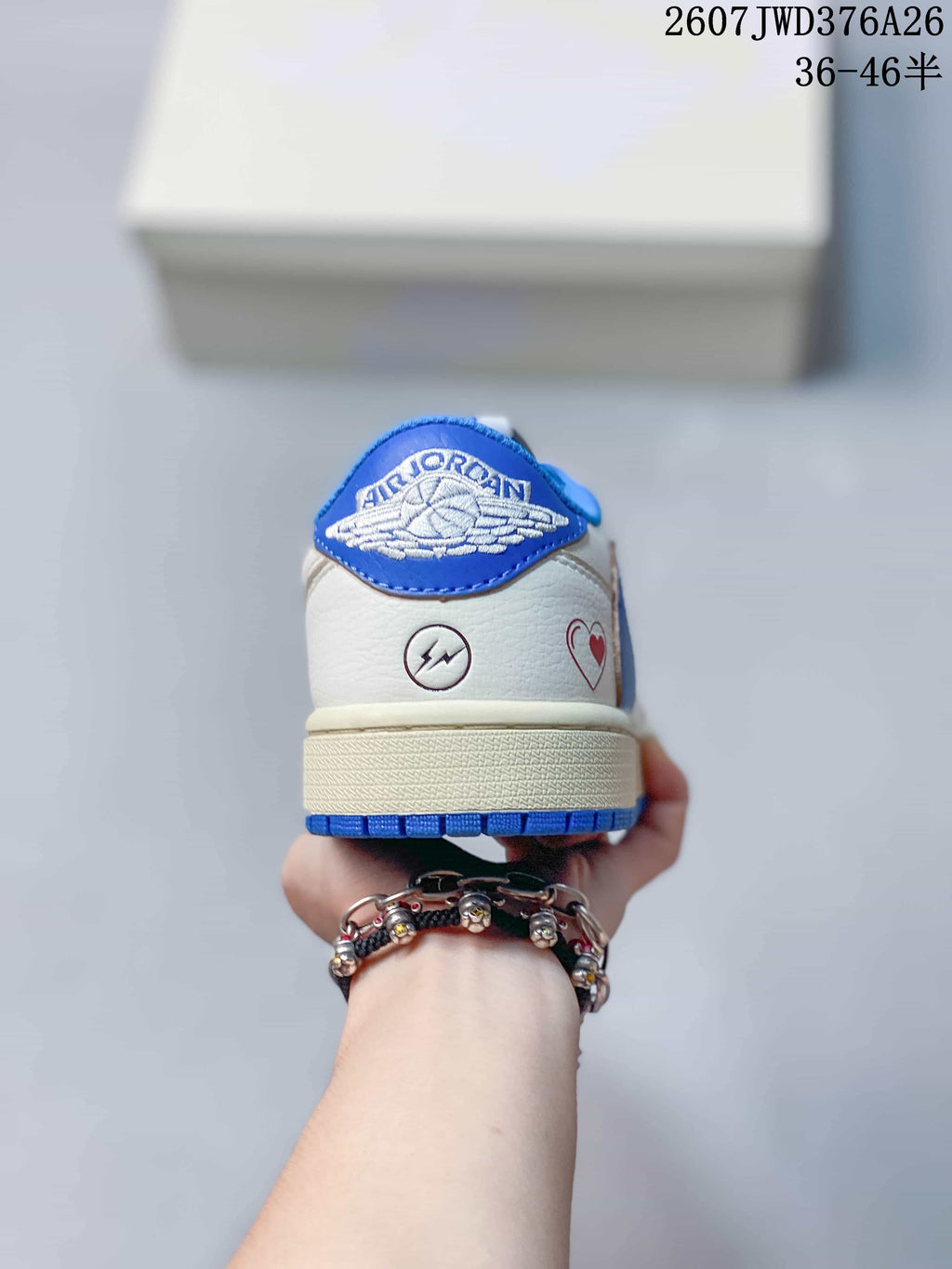 Rear view showing blue winged Jordan branding and decorative symbols on the white heel.