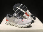 Angled view showing the outsole tread, segmented white midsole structure, and orange outsole detail.