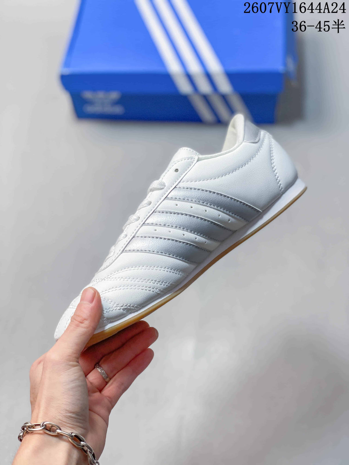 Side profile of the low-top sneaker showing silver stripes, white upper, and gum outsole.