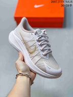 Angled side view of the white and gold Nike Zoom Winflo 8 sneaker.