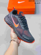 Angled side view showing the dark gray mesh upper, orange accents, lace system, and cushioned-looking midsole.