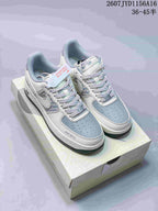 Pair of light grey and white low-top sneakers with blue-grey panels, patterned sides and a dark outsole, shown on a shoebox.