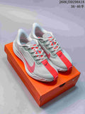 Pair of light grey and red Nike ReactX Pegasus Plus Next Nature sneakers displayed on an orange Nike shoebox.