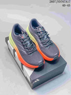 Pair of dark gray Adidas sneakers with bright orange midsoles and lime-green heel sections.