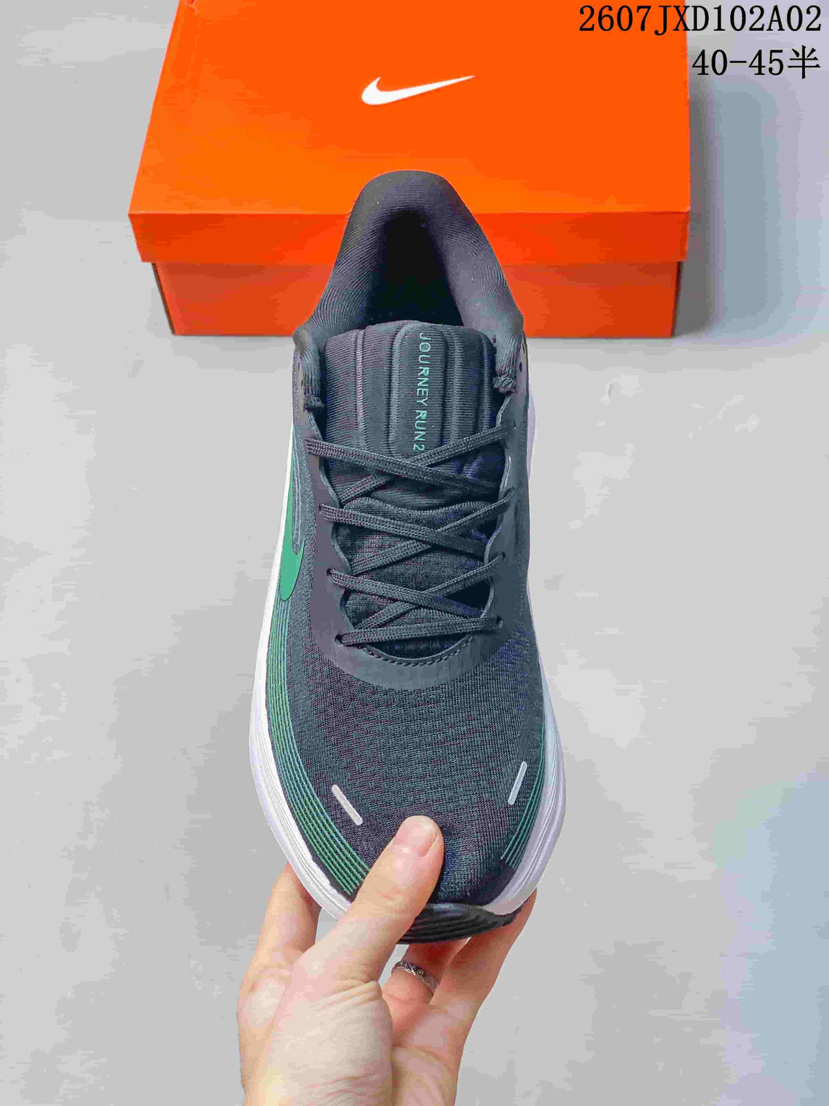 Top view of a charcoal Nike running shoe with green detailing and lace-up closure; tongue reads Journey Run 2, and image text shows 40–45.