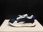Side view of one sneaker showing the black heel, blue upper panels, white detailing, and sculpted white midsole.