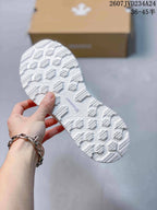 Close view of the white outsole showing its geometric traction pattern.