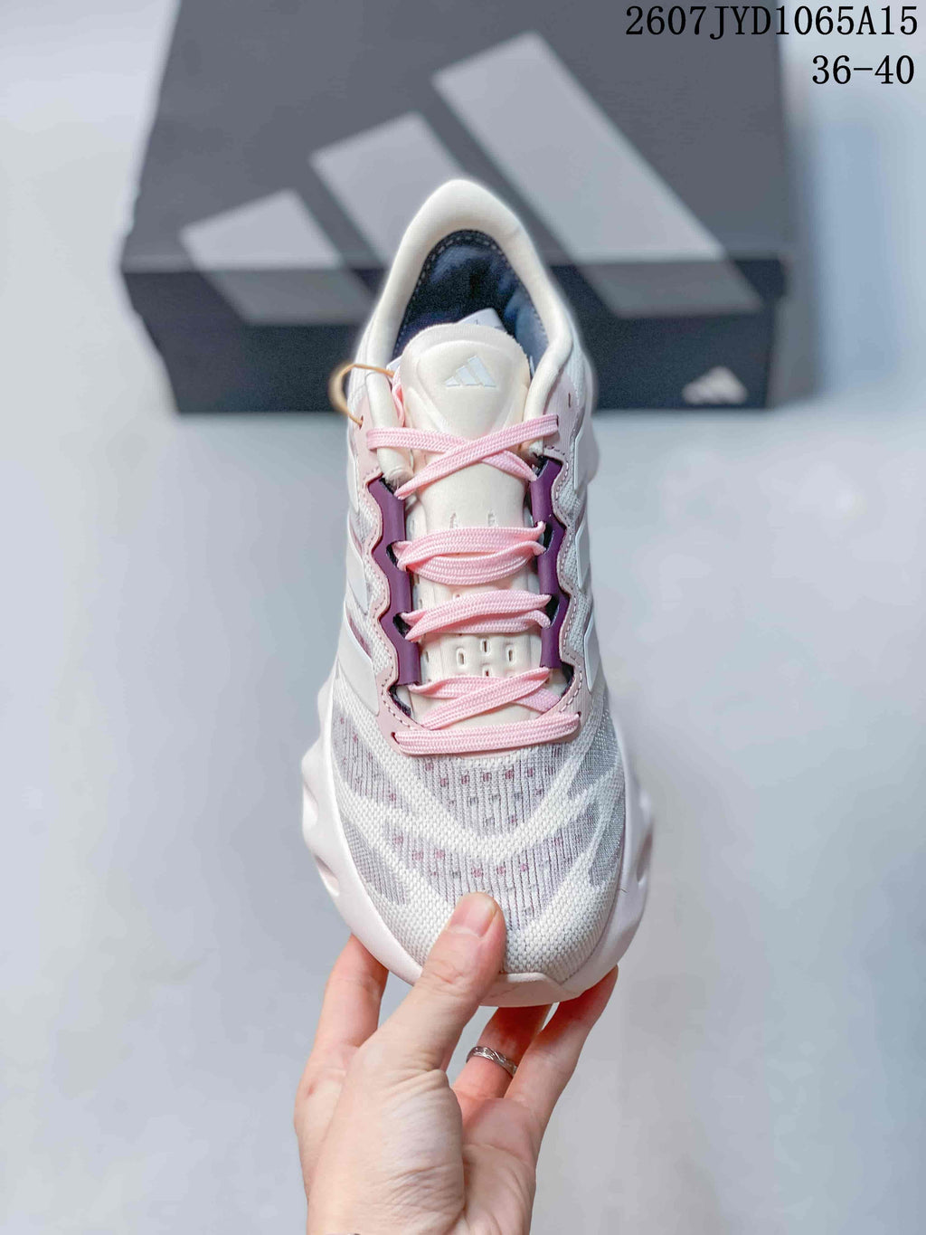 Front view showing the textured white upper, pink laces, and purple side detailing.
