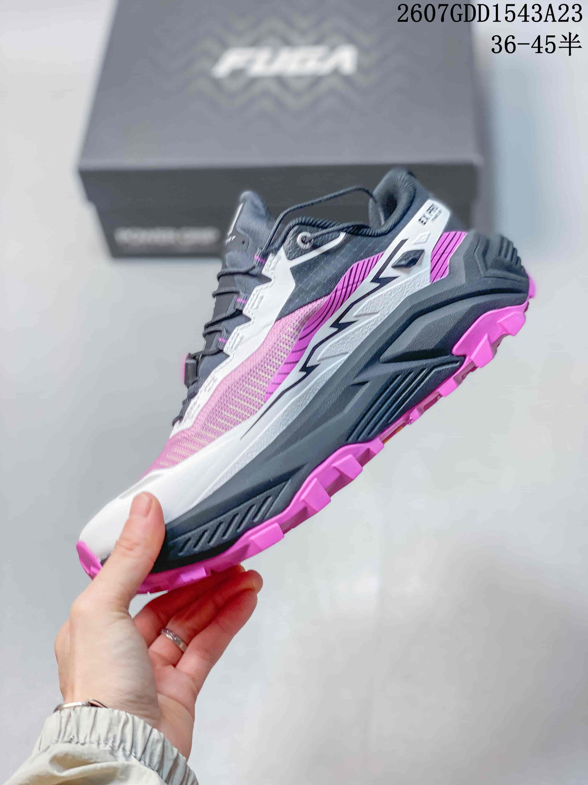 Side view showing the pink mesh-like upper, white overlays, black midsole, and pink tread.