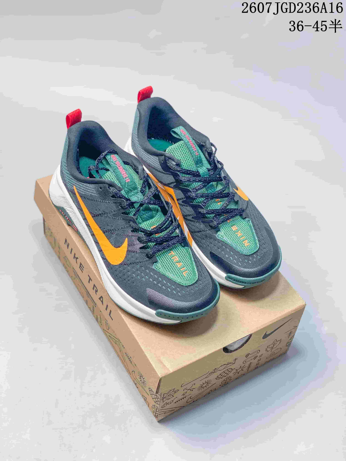 Pair of dark gray Nike ReactX Wildhorse 10 trail sneakers with orange and green accents displayed on a branded shoe box.