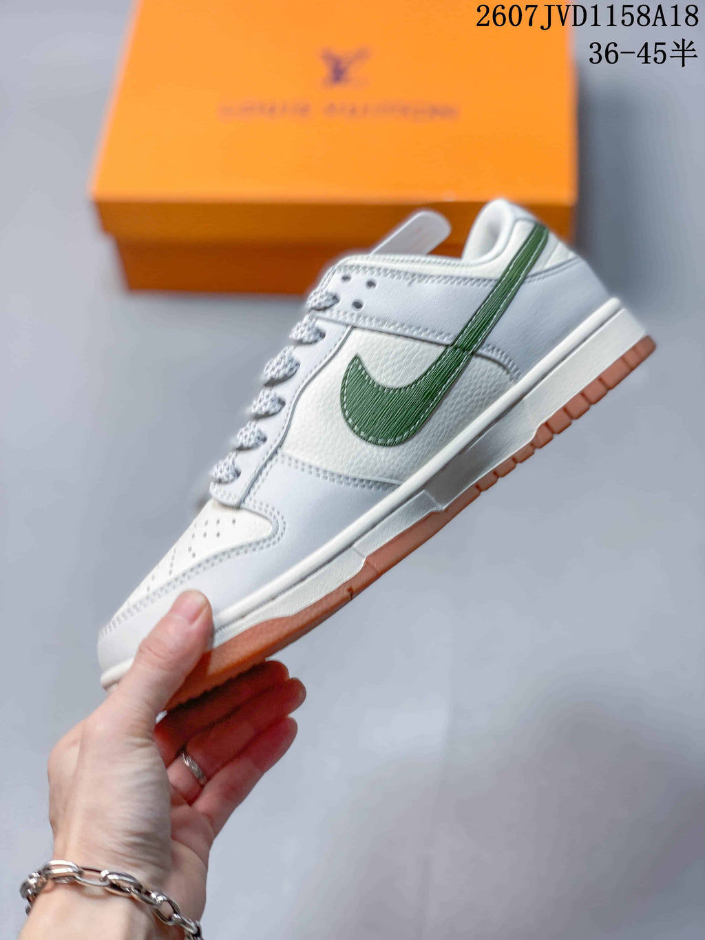 Side profile of a white low-top sneaker with a green side overlay, white midsole, and gum-colored outsole.