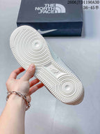 Close-up of the sneaker outsole beside a box bearing The North Face branding