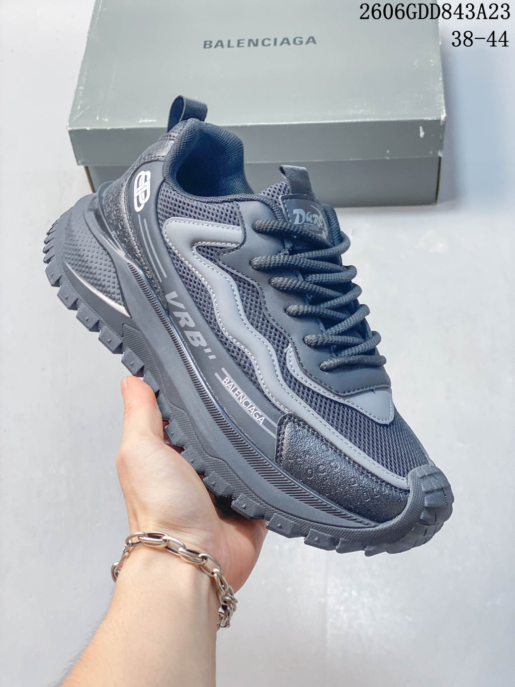 Angled side view of the grey sneaker with visible branding and layered details.
