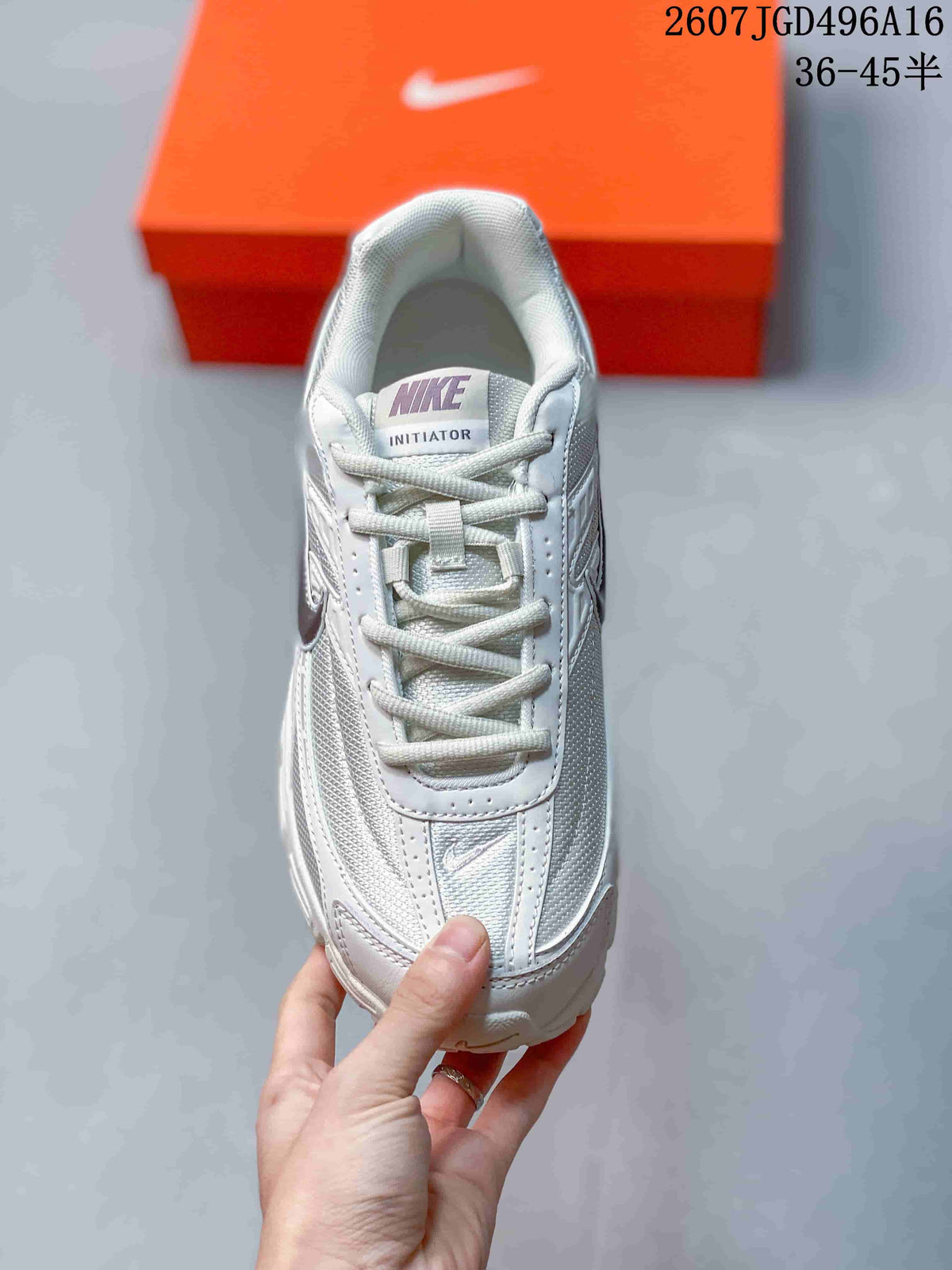 Top view of a white and grey Nike Initiator sneaker showing the laces, tongue label and perforated upper details.
