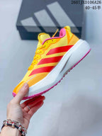 Side view showing the yellow upper, red side stripes, white midsole and pink outsole.