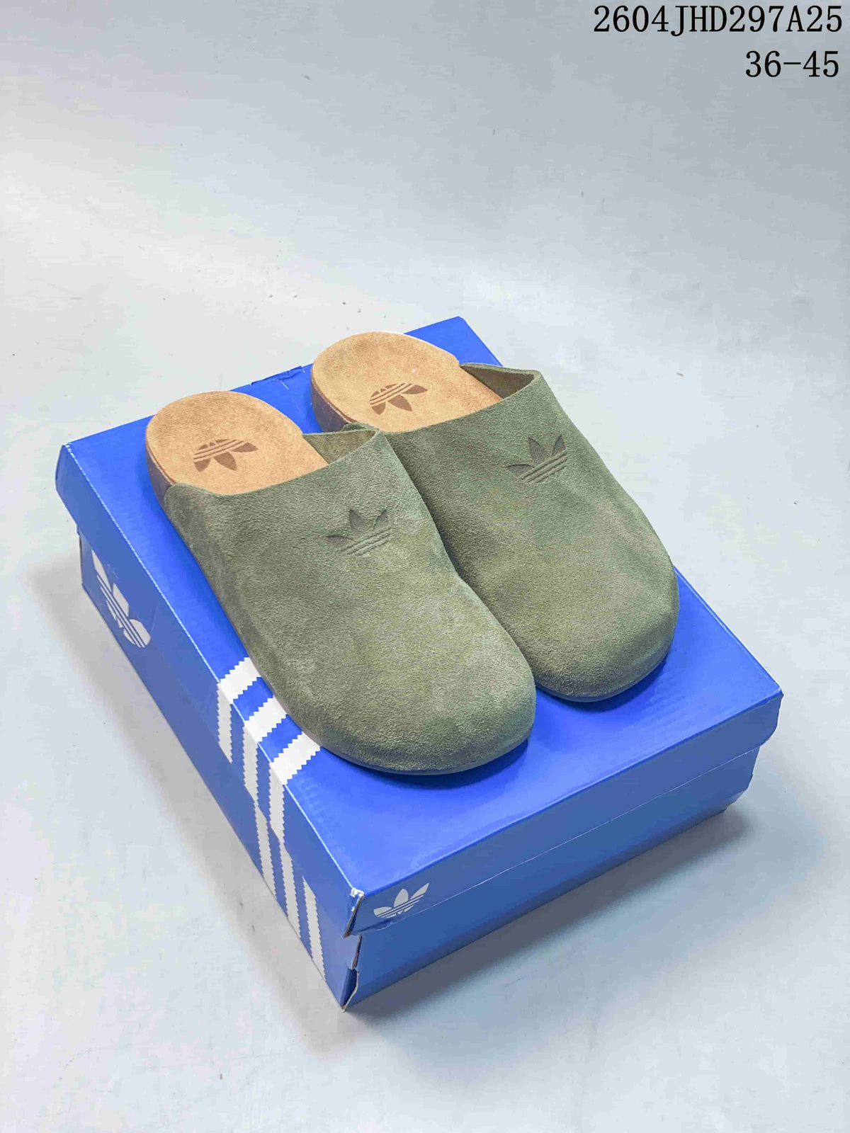 Pair of green Adidas Originals Adimule closed-toe mules on a blue box