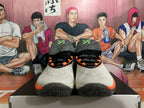Front view of Nike basketball shoes with a light upper, black laces, and orange accents