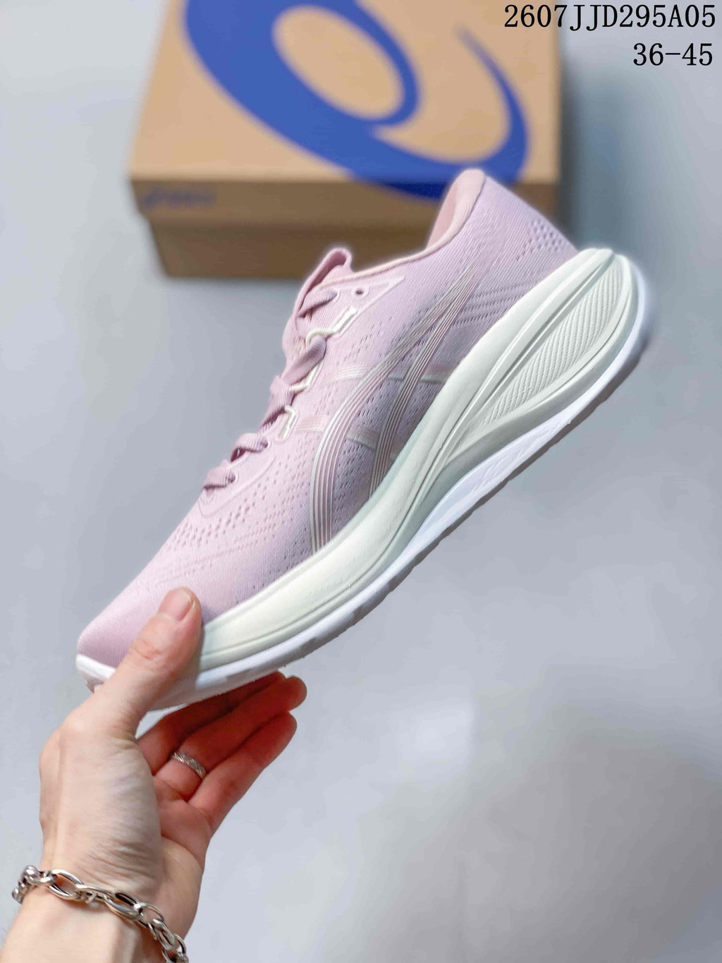 Side profile showing the pink knit upper, ASICS side detailing, layered white midsole, and outsole.