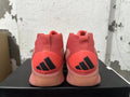 Rear view of pink Adidas mid-top sneakers with black heel logos.