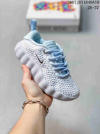 White Nike Mind 002 kids sneaker shown from a three-quarter angle with perforated details.