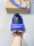 Rear view showing the padded heel, pull tab and purple midsole of the running shoe.