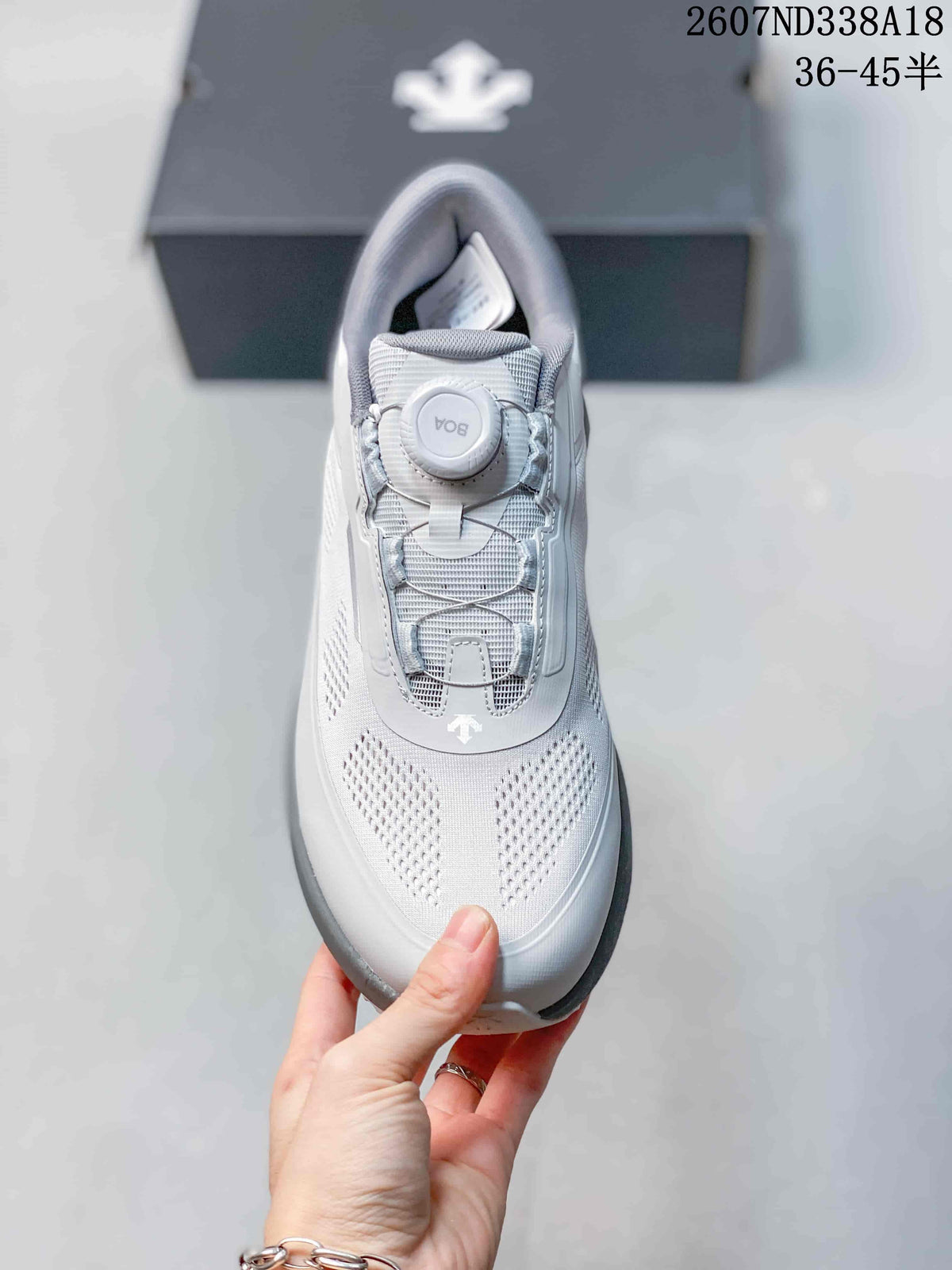 Top view of a sneaker showing the perforated toe area, mesh tongue, round dial fastening system, and lace-like support cables.