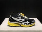 Close side view of one sneaker showing the arrow graphics, mesh panels, contrast laces, and yellow outsole.