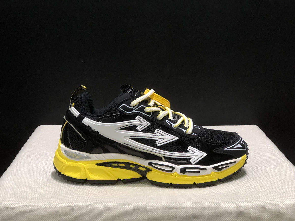 Close side view of one sneaker showing the arrow graphics, mesh panels, contrast laces, and yellow outsole.