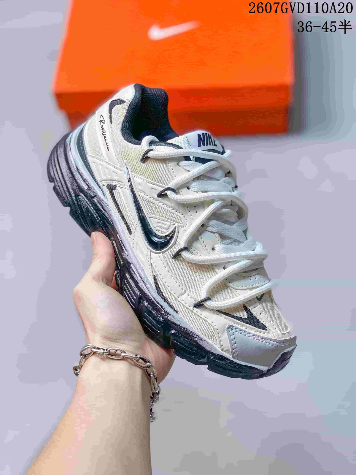 Angled side view of the Nike Initiator sneaker showing the layered grey and white upper, dark Swoosh detail, padded collar, and textured sole.