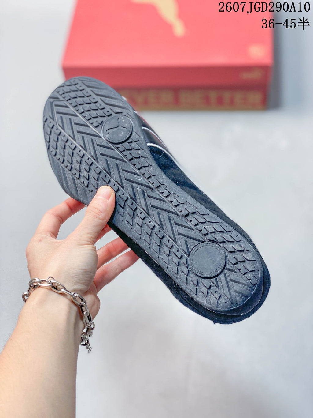 Underside view showing the sneakers' patterned black rubber outsole and circular tread areas.