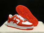Angled view of the sneakers with one shoe lifted to show the orange patterned outsole and star detail.