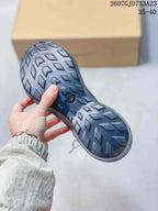 Close view of the sneaker outsole showing a dark geometric tread pattern and central logo detail.