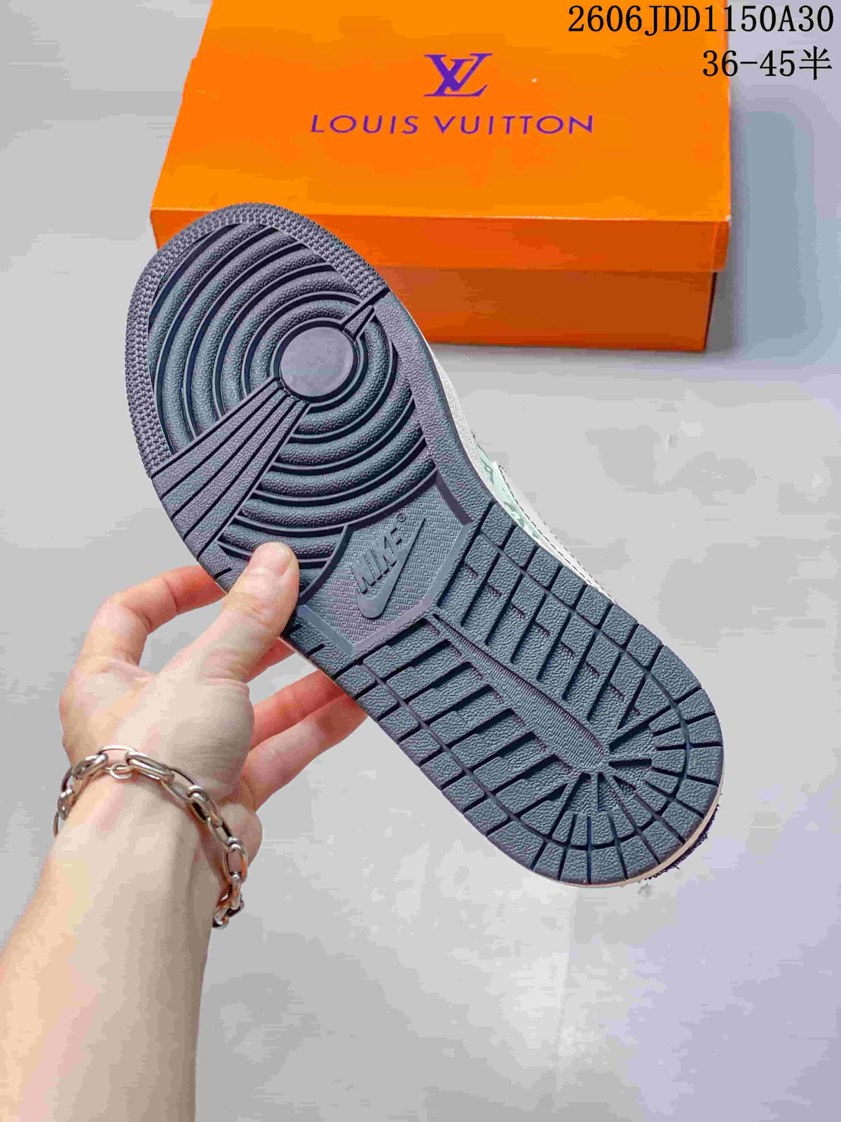 Close-up of the sneaker outsole with concentric tread and an orange shoebox behind it