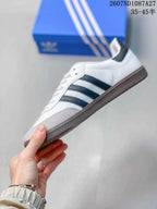 Side profile showing the low-top silhouette, black three stripes, white upper and gray toe area.