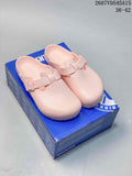 Pair of pink closed-toe buckle sandals displayed on a blue shoebox.